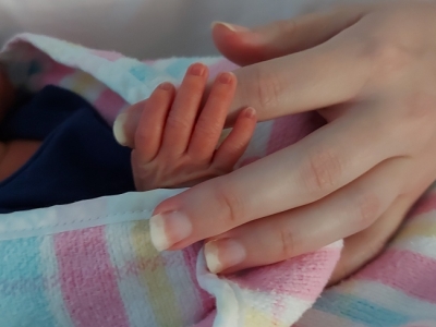 baby hand holding onto mother's finger